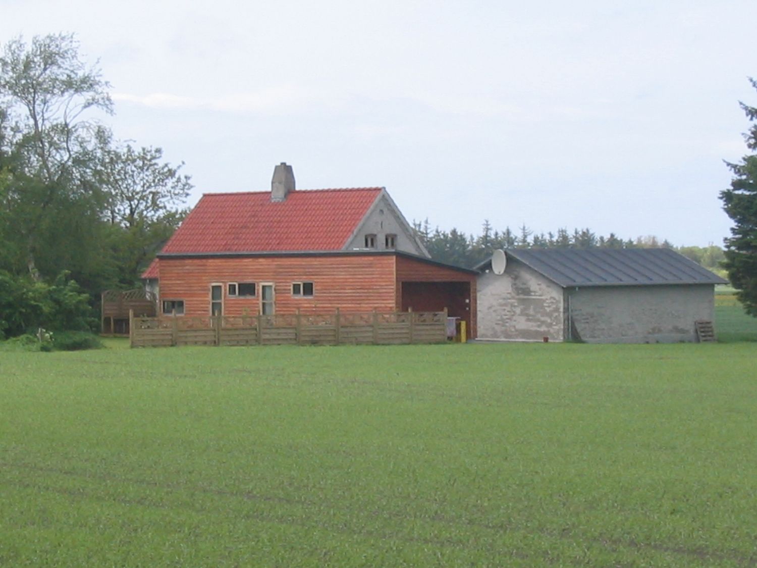 Landejendom med rødt tag og udhus